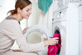 Mädchen befüllt eine Waschmaschine